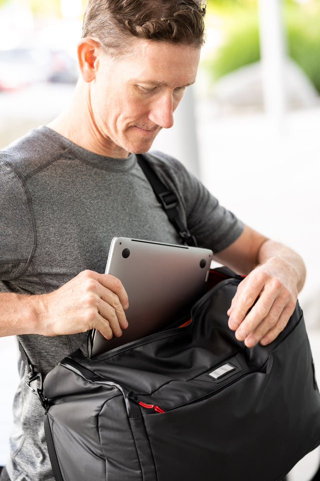 Two Wheel Gear - Man pulling out laptop from Spin Backpack Messenger Bag 