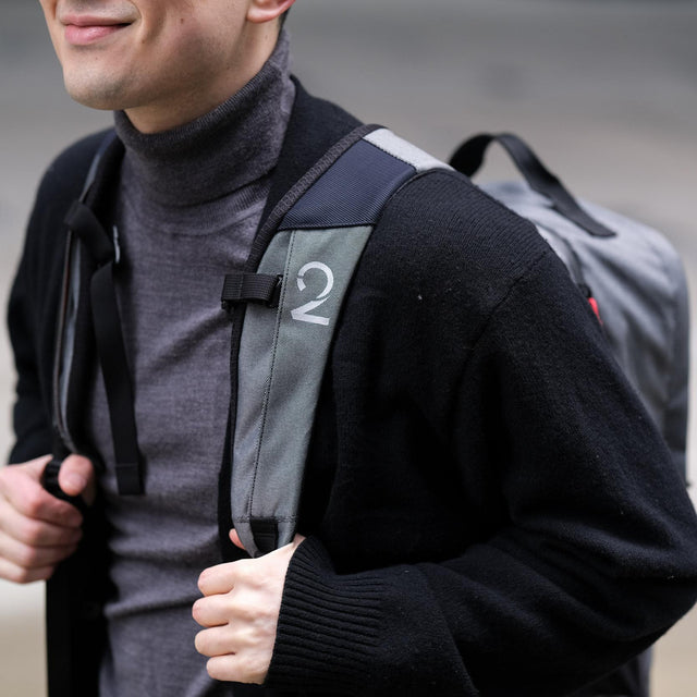 Person wearing a backpack with a visible two wheel gear logo on a pannier backpack 2.1 Plus on front backpack strap