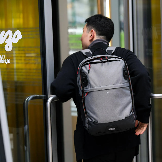 Man with Grey Pannier Backpack PLUS 2.1 on his back entering a business