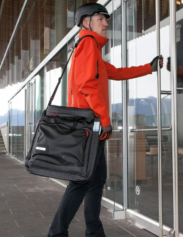 Man walking into office building with a Two Wheel Gear Garment Pannier - Classic 3.0