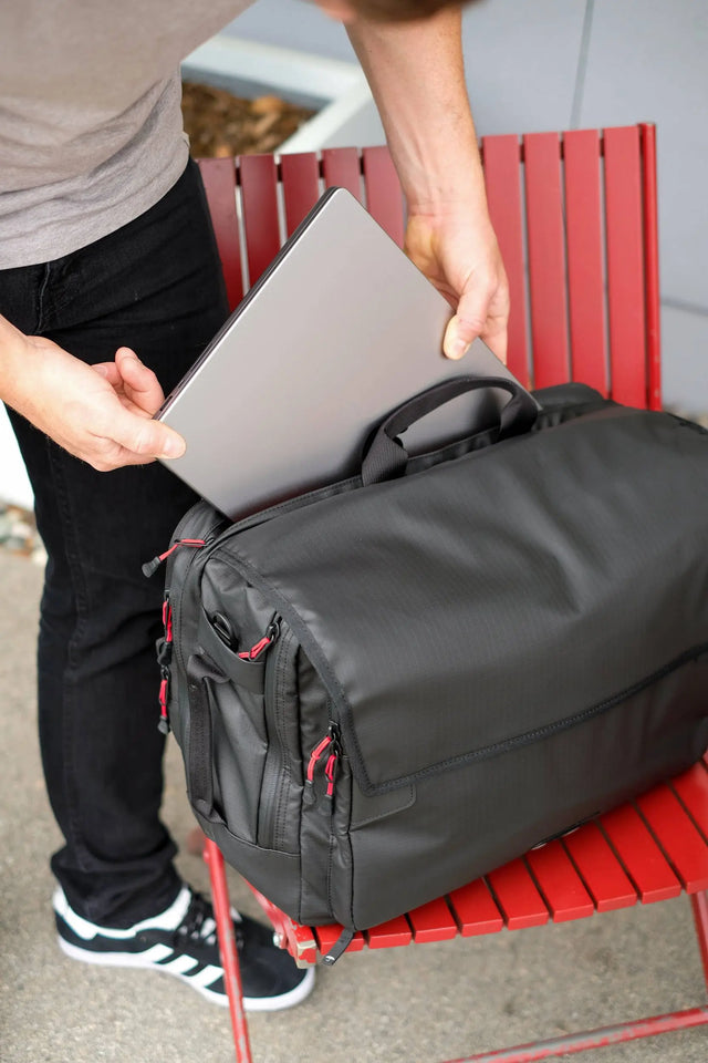 Weatherproof laptop pannier in recycled ripstop fabric with 16" laptop being loaded into bike bag