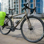 Two Wheel Gear Grey Inverter Pannier Backpack with rain cover attached to commuter bicycle