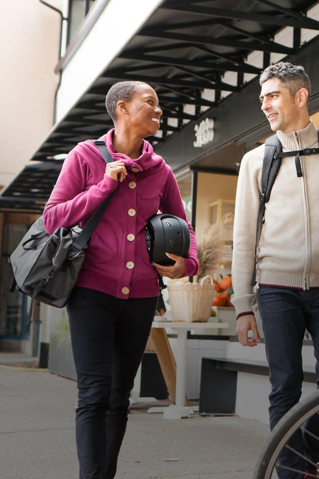 Happy woman carrying Two Wheel Gear bike bag with shoulder strap talking to friend.